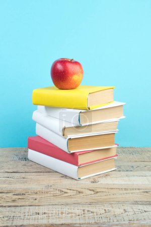 Photo for Books stacking. Books on wooden table and blue background. Back to school. Copy space for ad text - Royalty Free Image