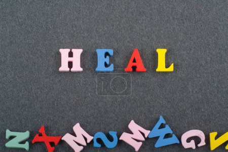 Photo for HEAL word on black board background composed from colorful abc alphabet block wooden letters, copy space for ad text. Learning english concept - Royalty Free Image