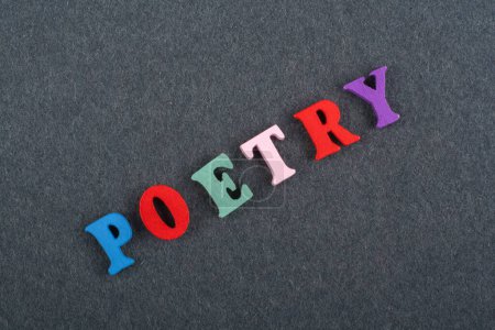 POETRY word on black board background composed from colorful abc alphabet block wooden letters, copy space for ad text. Learning english concept