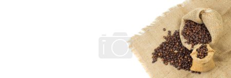Open burlap bags scattered with whole coffee beans on a white background. Banner