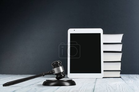 Gesetzeskonzept - offenes Gesetzbuch mit einem hölzernen Richtergabel auf dem Tisch in einem Gerichtssaal oder einer Strafverfolgungsbehörde auf blauem Hintergrund. Kopierraum für Text