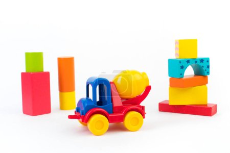 Juguetes infantiles, coche multicolor, cubos constructores de madera sobre un fondo blanco. Para el desarrollo del niño.