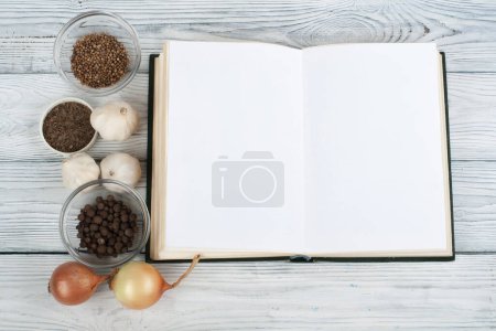 Recipe cook blank book on wooden background, spoon, rolling pin, checkered tablecloth.