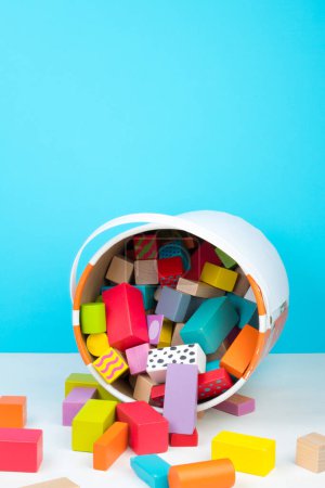 Children's toy, wooden constructor, poured out of a bucket on a white background