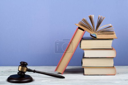 Photo for Law concept open book with wooden judges gavel on table in a courtroom or law enforcement office, blue background. Copy space for text - Royalty Free Image