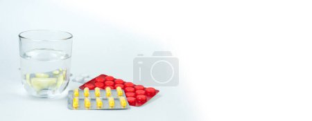 Photo for Pharmaceuticals pills, tablet and capsules medicine, glass of water on white background. to take medicine. - Royalty Free Image