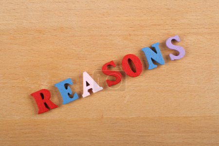 REASONS word on wooden background composed from colorful abc alphabet block wooden letters, copy space for ad text. Learning english concept
