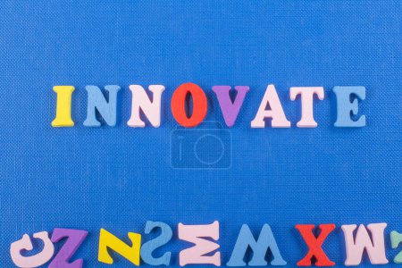 innovateword auf blauem Hintergrund bestehend aus bunten Abc-Buchstaben Block Holzbuchstaben, Kopierraum für Anzeigentext. Englischlerndes Konzept