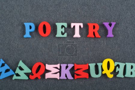 POETRY word on black board background composed from colorful abc alphabet block wooden letters, copy space for ad text. Learning english concept