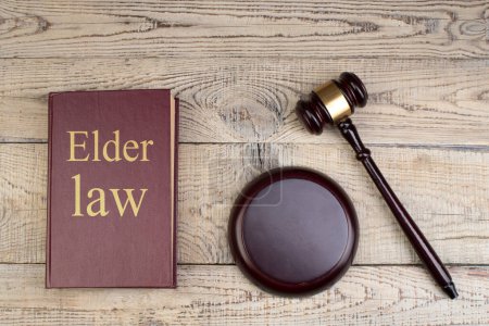 Photo for Law concept - Open law book with a wooden judges gavel on table in a courtroom or law enforcement office on the wooden background. Copy space for text - Royalty Free Image