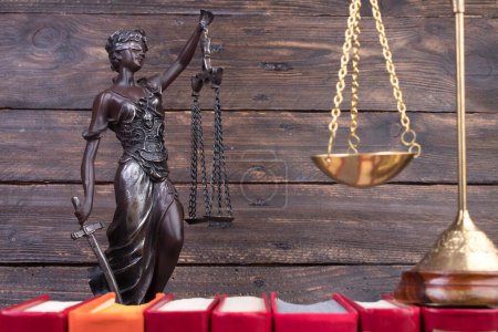 Rechtskonzept - Offenes Gesetzbuch, Richtergabel, Waage, Themis Statue auf dem Tisch im Gerichtssaal oder in der Strafverfolgungsbehörde. hölzerner Hintergrund.