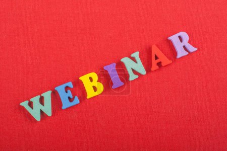 WEBINAR word on red background composed from colorful abc alphabet block wooden letters, copy space for ad text. Learning english concept