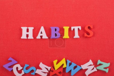 HABITS word on red background composed from colorful abc alphabet block wooden letters, copy space for ad text. Learning english concept