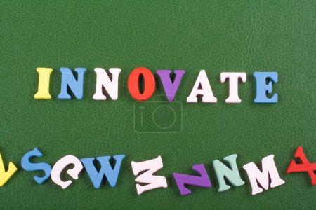 INNOVATE word on green background composed from colorful abc alphabet block wooden letters, copy space for ad text. Learning english concept