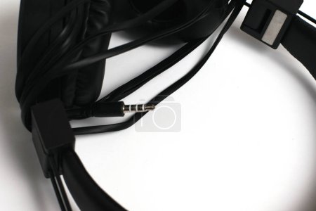Photo for Black headphones with a wire on a white background, jack close-up. Cheap headphones for listening to music. - Royalty Free Image