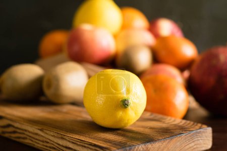 Téléchargez les photos : Fruits dans un sac réutilisable. Jour de la Terre et concept zéro déchet. Orange, citron macro, pomme, kiwi, grenade et planche à découper en bois sur fond sombre. - en image libre de droit