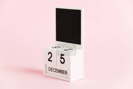 Foto de Navidad, calendario de madera con la fecha 25 de diciembre sobre un fondo rosa. Concepto de celebración de Navidad y Año Nuevo - Imagen libre de derechos