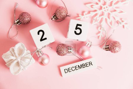 Foto de Flatlay, Navidad, calendario de madera con fecha 25 de diciembre y decoraciones de árboles de Navidad sobre fondo rosa. Concepto de celebración de Navidad y Año Nuevo - Imagen libre de derechos