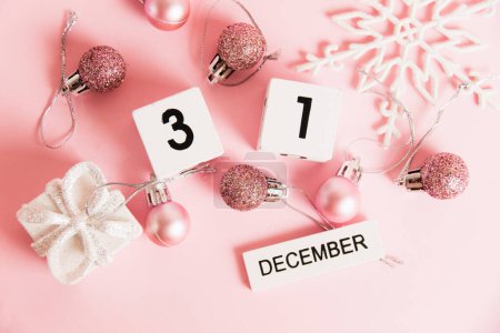 Foto de Flatlay, Año Nuevo, calendario de madera con fecha 31 de diciembre y decoraciones de árboles de Navidad sobre fondo rosa. Concepto de celebración de Navidad y Año Nuevo - Imagen libre de derechos