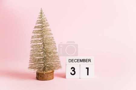 Foto de Decoración navideña y calendario con fecha 31 de diciembre sobre papel rosa con espacio para copiar, Año Nuevo. Concepto de celebración de Navidad y Año Nuevo - Imagen libre de derechos