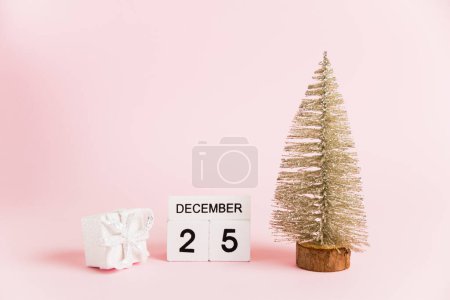 Foto de Decoración navideña y calendario con fecha 25 de diciembre sobre papel rosa con espacio para copiar. Concepto de celebración de Navidad y Año Nuevo - Imagen libre de derechos