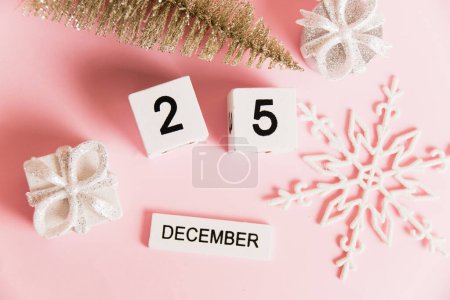 Foto de Flatlay, decoración navideña y calendario con fecha 25 de diciembre sobre fondo de papel rosa con espacio para copiar. Concepto de celebración de Navidad y Año Nuevo - Imagen libre de derechos