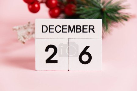 Foto de Rama de árbol de decoración de Navidad y calendario con fecha 26 de diciembre en papel rosa con espacio para copiar. Concepto de celebración de Navidad y Año Nuevo - Imagen libre de derechos