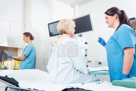 Téléchargez les photos : Infirmière expliquant la procédure au patient en chirurgie hospitalière pour soulager l'anxiété - en image libre de droit