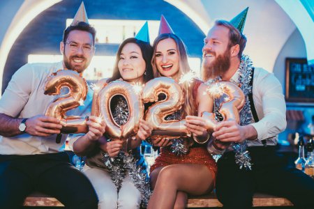 Foto de Mujeres y hombres celebrando el nuevo año 2023 con vino - Imagen libre de derechos