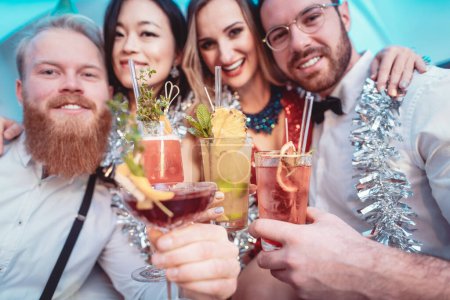Téléchargez les photos : Groupe de jeunes amis souriants tenant des cocktails à la main regardant la caméra - en image libre de droit