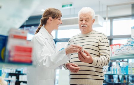 Foto de Hombre mayor con farmacéutico en farmacia que compra un medicamento recetado - Imagen libre de derechos