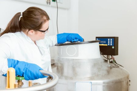 Foto de Young female researcher using liquid nitrogen machinery laboratory for experimentation - Imagen libre de derechos