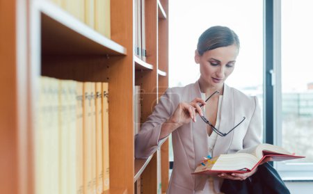 Photo for Lawyer woman reading in the library of the law firm reading - Royalty Free Image