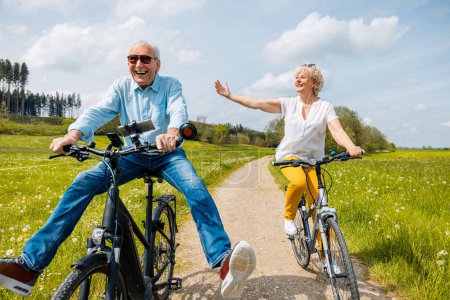 Senioren haben Spaß auf Fahrrädern in Frühlingslandschaft