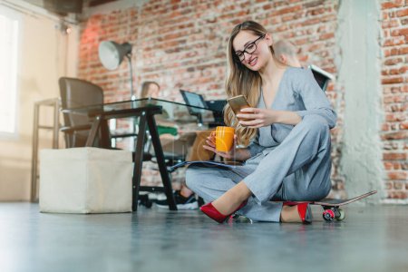 Téléchargez les photos : Femme dans un bureau haut assis sur le sol de travail - en image libre de droit