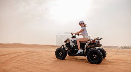 Foto de Mujer montando dunas de arena ATV en el desierto de Dubai - Imagen libre de derechos