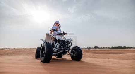 Foto de Mujer montando dunas de arena ATV en el desierto de Dubai - Imagen libre de derechos