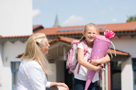 First day in school for little girl with candy cone