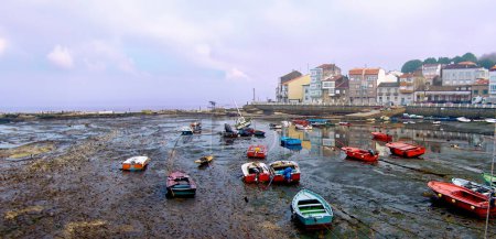 Photo for In the serene landscapes of Ras Baixas in Galicia, boats rest on the sandy shores as the tide retreats, - Royalty Free Image
