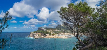 Téléchargez les photos : Vue panoramique montrant la baie de Port de Sollers entourée par les sommets de Serra de Tramuntanas sous un ciel bleu vif avec des nuages. - en image libre de droit