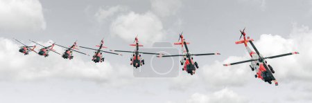 Una escena dramática de cinco helicópteros ejecutando un vuelo de formación coordinada, frente a un contrastante cielo nublado.