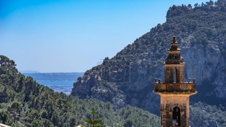 Cartuja de Valldemossa tower stands tall amidst pine-covered cliffs and sea views