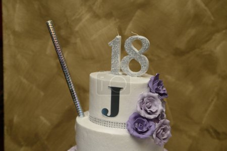 Téléchargez les photos : Photo en gros plan d'un gâteau d'anniversaire avec une bougie en forme du chiffre 18 et la lettre majuscule J - en image libre de droit