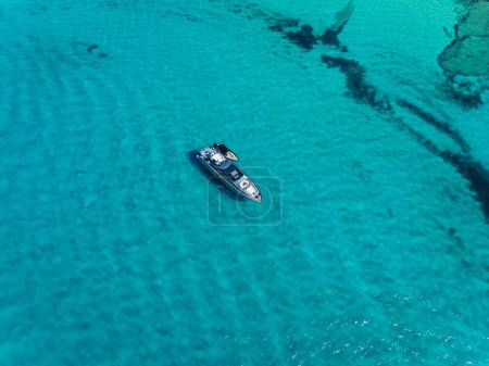 Yate de motor caro amarrado en una bahía turquesa pacífica