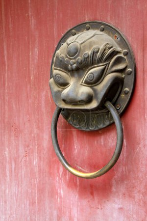 Photo for Closeup of pictures, metal beast head knocker on red door plank - Royalty Free Image