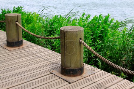 Téléchargez les photos : Wood chopping block and mooring rope by the lake - en image libre de droit