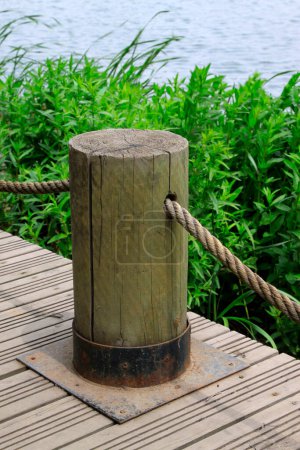 Foto de Wood chopping block and mooring rope by the lake - Imagen libre de derechos