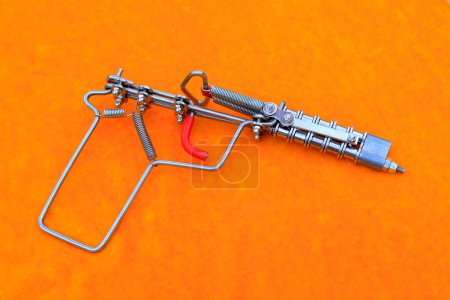 Téléchargez les photos : Toy guns made by iron wire in orange background - en image libre de droit