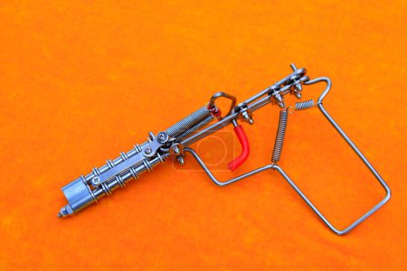 Téléchargez les photos : Toy guns made by iron wire in orange background - en image libre de droit