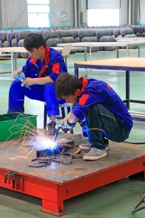 Téléchargez les photos : TANGSHAN CITY - MAY 28: Worker welding parts in the production workshop, on may 28, 2014, Tangshan city, Hebei Province, Chin - en image libre de droit
